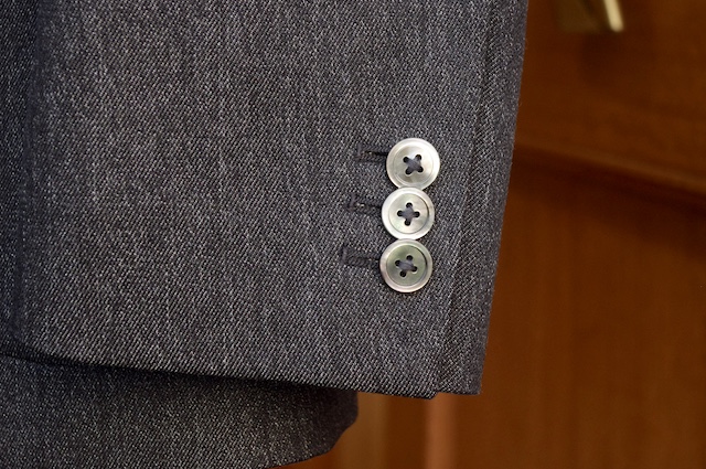 袖口に黒蝶貝のボタンを合わせた、ドレスカジュアルな、黒のウールデニムスーツ。